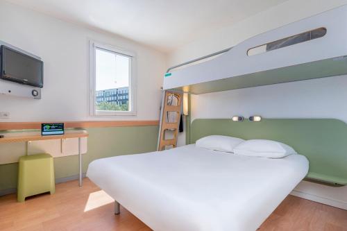 sypialnia z łóżkiem, biurkiem i telewizorem w obiekcie B&B HOTEL Aix-en-Provence Meyreuil Sainte-Victoire w mieście Meyreuil