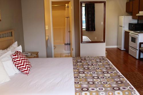 a bedroom with a white bed with two pillows on it at Days Inn by Wyndham Lakewood South Tacoma in Lakewood