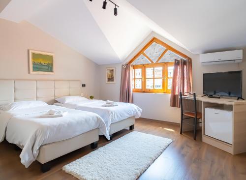 a bedroom with two beds and a television at Garden Boutique B&B in Tirana