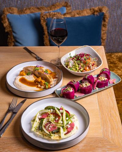 a table with plates of food and a glass of wine at Grand Hôtel Du Palais Royal in Paris