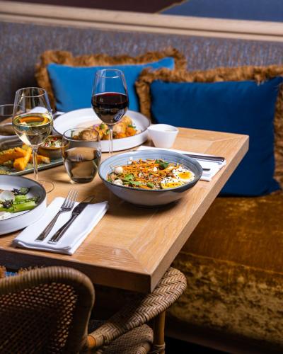 a wooden table with plates of food and glasses of wine at Grand Hôtel Du Palais Royal in Paris
