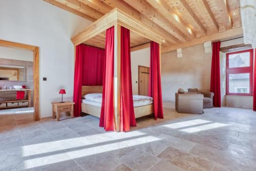 1 dormitorio con 1 cama con cortinas rojas en Château de Vieux Moulin 