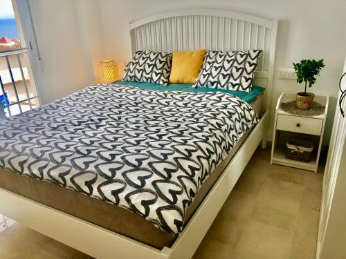 1 cama con edredón blanco y negro en un dormitorio en Blue Sunrise Penthouse - Manilva, en Manilva