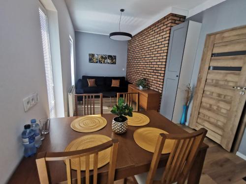 a dining room with a wooden table and chairs at Chcę tu zostać Apartamenty Gdynia in Gdynia