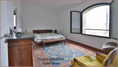 een woonkamer met een bank en een raam bij Le Patio Centre ville PEZENAS in Pézenas