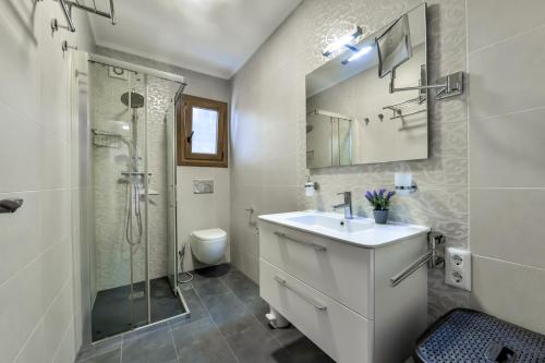 ein weißes Badezimmer mit Waschbecken und Dusche in der Unterkunft Villas Guzman - Las Rosas in Benissa