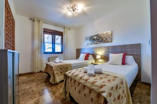 ein Hotelzimmer mit zwei Betten und einem Fenster in der Unterkunft Villas Guzman - Las Rosas in Benissa