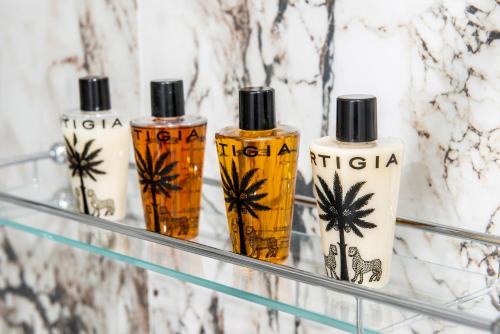 four bottles of hair products sitting on a shelf at Hotel President in Viareggio