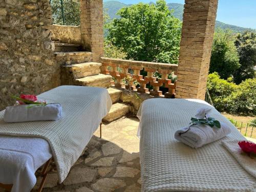 two white beds sitting on top of a patio at Les Horizons - SPA-JACUZZI - MASSAGE- SAUNA - 4 SAISONS - Piscine chauffée Toute l'année - 800m centre ville Nyons in Nyons