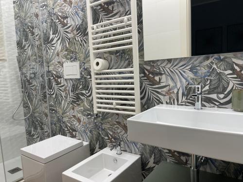 Un baño con lavabo, inodoro y espejo. en Lalù B&B, en Altamura