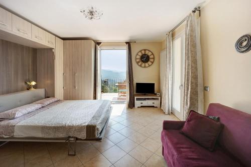 Diano BorelloにあるMaison Lauraのベッドルーム1室(ベッド1台、ソファ、窓付)