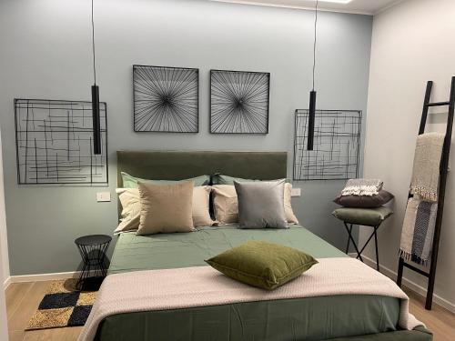 1 dormitorio con 1 cama verde y 3 cuadros en la pared en Lalù B&B, en Altamura