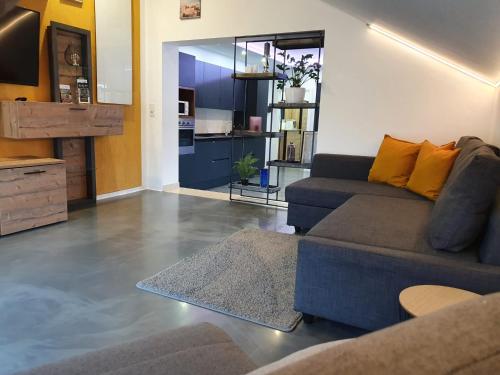 a living room with a couch and a kitchen at Zum kleinen Italiener - Ristorante Pizzeria Pension in Geinberg