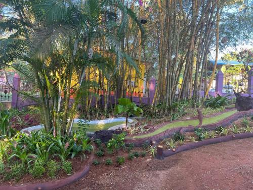 a garden with trees and plants in front of a building at Vishram Village in Varkala
