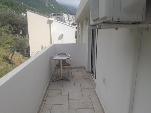 a small balcony with a stool on a white wall at Vila Horizont in Sveti Stefan