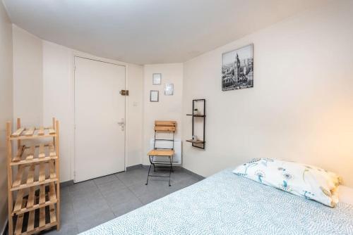 ein Schlafzimmer mit einem Bett und einem Stuhl darin in der Unterkunft L'harmonie in Amiens