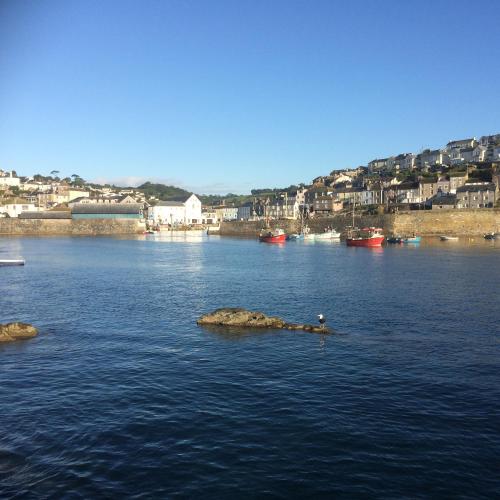a river with rocks in the water with houses at The Mandalay Guest House in Mevagissey