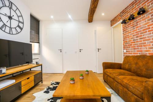 a living room with a couch and a coffee table at Superbe Appartement - Hyper Centre - 2 Chambres - WIFI in Grasse