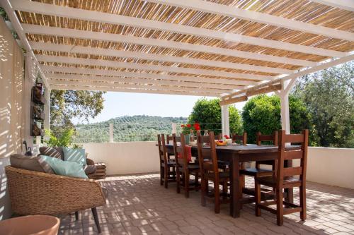 a patio with a wooden pergola and a table and chairs at Oliveto Bed and Breakfast in Alghero