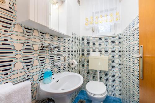 een badkamer met een wit toilet en een wastafel bij Apartment AdriaHouse in Punat