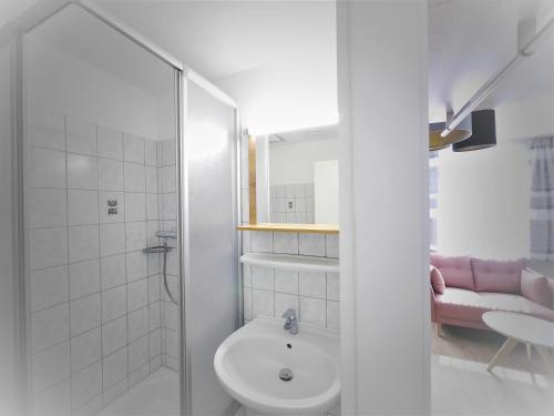 a white bathroom with a sink and a toilet at Zur Eiche in Ahlbeck