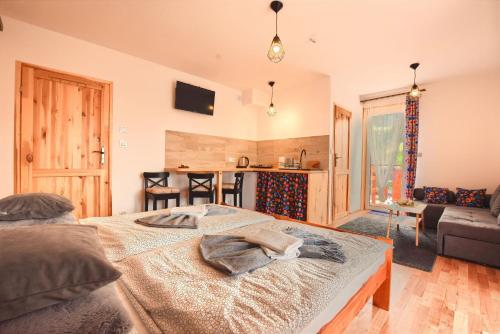 a bedroom with a bed and a living room at Apartamenty Soszów in Wisła