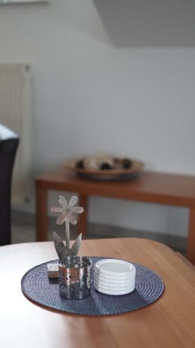 ein Tisch mit Platten und ein Blumendekor auf dem Tisch in der Unterkunft Ferienwohnung Kalltalblick in Simmerath