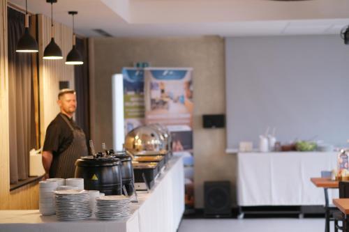 a man standing behind a counter in a kitchen at Rezort Maladinovo pri Liptovskej Mare in Liptovský Mikuláš