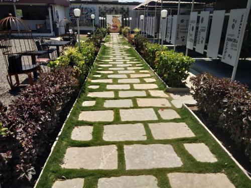 a walkway with grass and stones in a garden at Hotel Krishna Exotica in Ahmadnagar