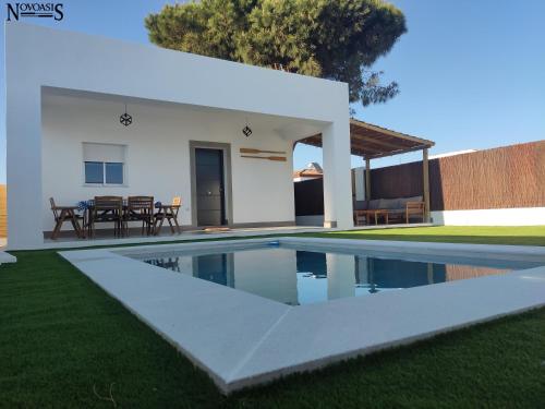 a swimming pool in front of a villa at Novoasis in Chiclana de la Frontera