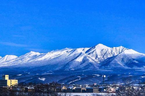 a snow covered mountain range with a city and buildings at Furano CUBE SUGAR-方糖民宿,步行8min到雪场,3 brs,Max 6ppl in Furano