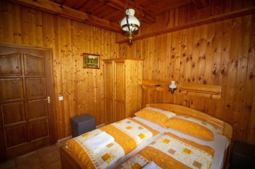 a bedroom with a bed in a wooden room at Radics Panzió Étterem és Pihenő Központ in Letenye