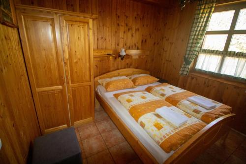a bedroom with a bed in a wooden room at Radics Panzió Étterem és Pihenő Központ in Letenye