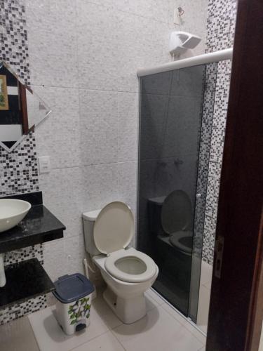 ein Bad mit einem WC und einer Glasdusche in der Unterkunft Recanto Cote Gil in Olímpia