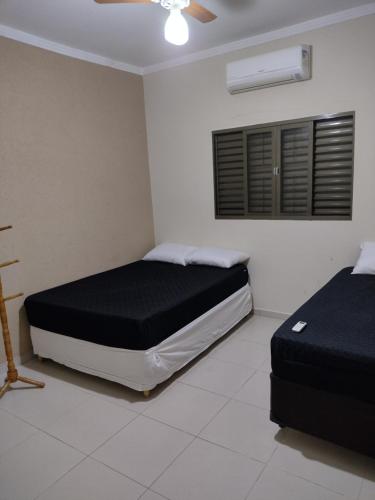 1 Schlafzimmer mit 2 Betten und einem Deckenventilator in der Unterkunft Recanto Cote Gil in Olímpia
