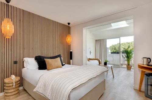 a bedroom with a large bed with a striped wall at Hôtel & Spa Les Mouettes in Argelès-sur-Mer
