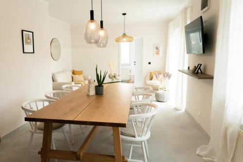 una sala da pranzo con tavolo in legno e sedie bianche di Familienapartment Reifnitz a Maria Wörth