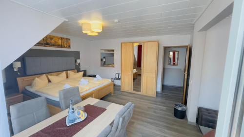 a bedroom with a bed and a living room at Hotel Schnehagen in Bad Fallingbostel