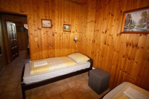 a small room with a bed in a wooden wall at Radics Panzió Étterem és Pihenő Központ in Letenye