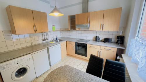a kitchen with wooden cabinets and a dishwasher at Hotel Schnehagen in Bad Fallingbostel