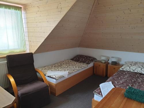 um quarto com uma cama e uma cadeira num quarto em Ubytování Benátky u Litomyšle em Litomysl