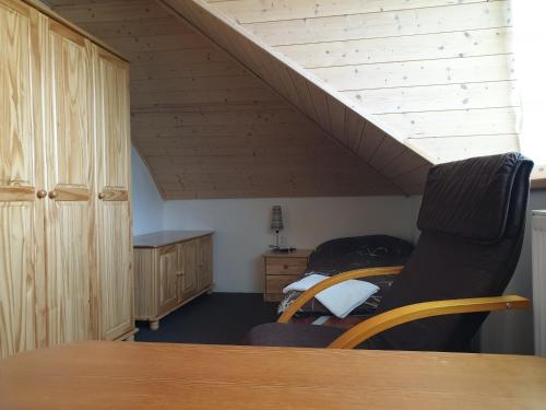 a attic room with a bed and a table and a staircase at Ubytování Benátky u Litomyšle in Litomyšl