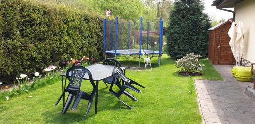 a table and chairs in a yard with a trampoline at Ubytování Benátky u Litomyšle in Litomyšl