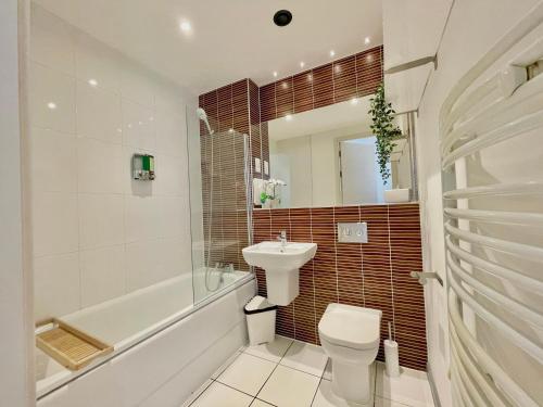 uma casa de banho com um lavatório, um WC e uma banheira em Victorian Factory Apartment with 2 Bedrooms em Bristol