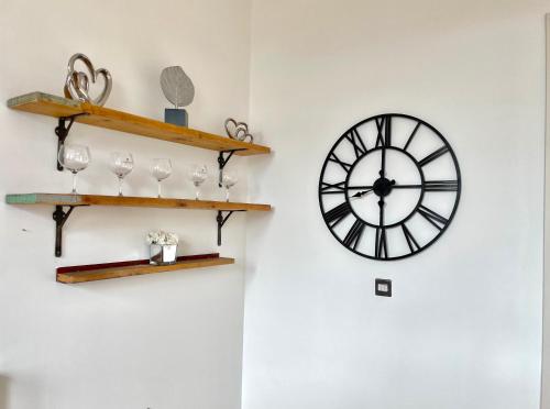un reloj en una pared con estanterías y copas de vino en Victorian Factory Apartment with 2 Bedrooms en Bristol