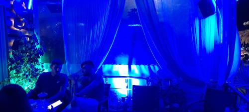 two people sitting in a room with blue lights at San Georgio Hotel in Tsoútsouros