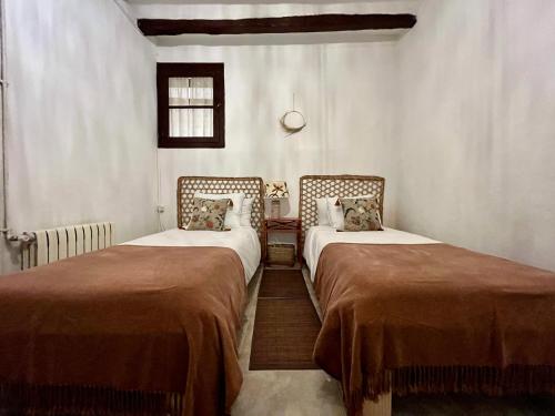 a room with two beds in a room at Cal Pere de L'Onclet in Montblanc