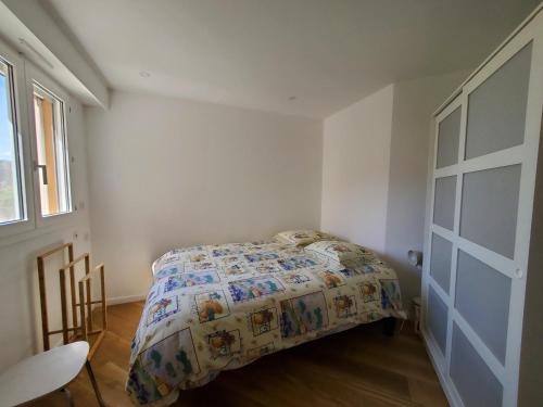 une chambre avec un lit avec une couette dessus dans l'établissement 2 Pieces 32m2 Plage a 150m, à Fréjus