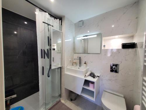 une salle de bain blanche avec un lavabo et une douche dans l'établissement 2 Pieces 32m2 Plage a 150m, à Fréjus