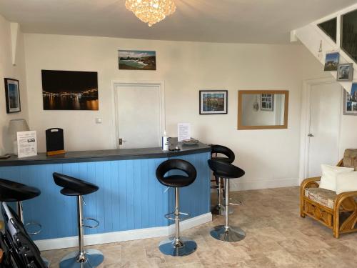 a hair salon with stools at a blue counter at The Mandalay Guest House in Mevagissey